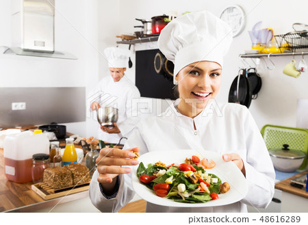 Woman chef serving fresh salad 48616289