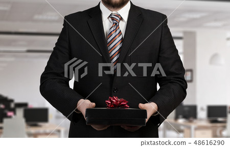 Businessman hold gift box Businessman hold gift box 48616290