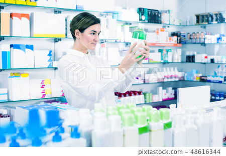 Female client is browsing rows of body care products Female client is browsing rows of body care products 48616344