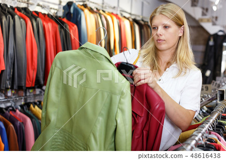 Woman choosing leather jacket Woman choosing leather jacket 48616438