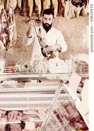 Handsome male seller showing jamon Handsome male seller showing jamon 48616439