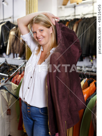 Woman trying on leather jacket Woman trying on leather jacket 48616456