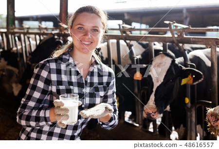 Woman with glass of milk on farm Woman with glass of milk on farm 48616557
