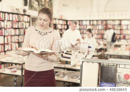 Woman looking for information in books in bookstore Woman looking for information in books in bookstore 48616643