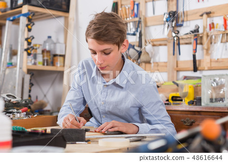 teenager smiling and working with wood in the workshop teenager smiling and working with wood in the workshop 48616644