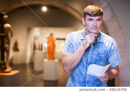 Man with information booklet in museum 48616700