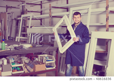 hardworking male professional labours with finished PVC profiles and windows hardworking male professional labours with finished PVC profiles and windows 48616836