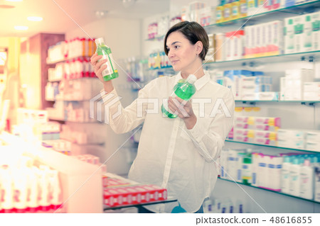 Beautiful woman customer browsing rows of drugs Beautiful woman customer browsing rows of drugs 48616855