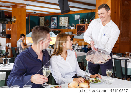 Waiter serving delicious fish dishes 48616857