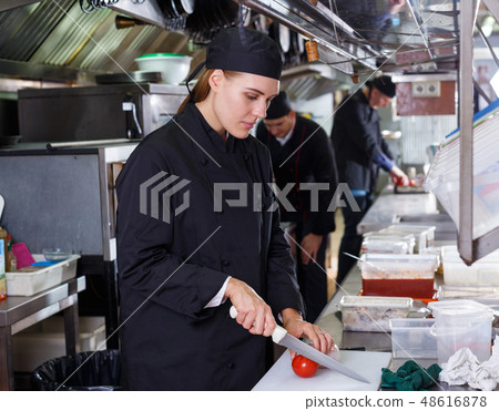 Friendly cooks in process of cooking dishes Friendly cooks in process of cooking dishes 48616878