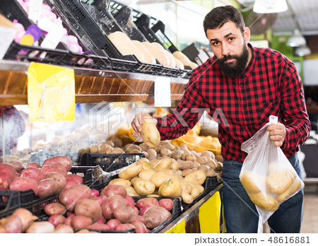 man seller showing potatoes man seller showing potatoes 48616881
