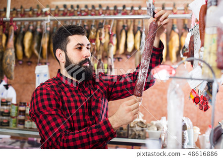 guy deciding on best sausage 48616886