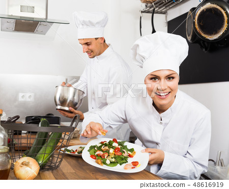 Adult happy female cook holding plate 48616919