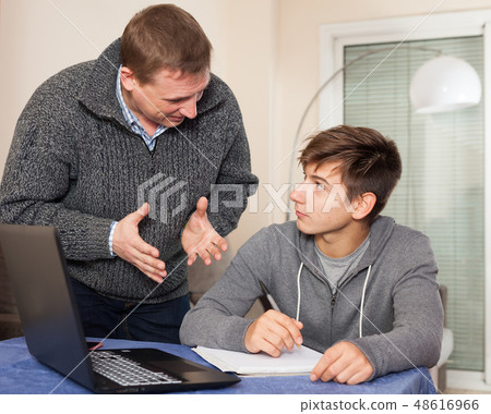 Father scolds son for poor grades in school 48616966