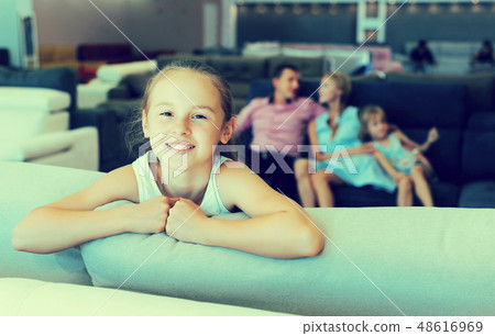 Girl is happy of the purchase of a new sofa Girl is happy of the purchase of a new sofa 48616969