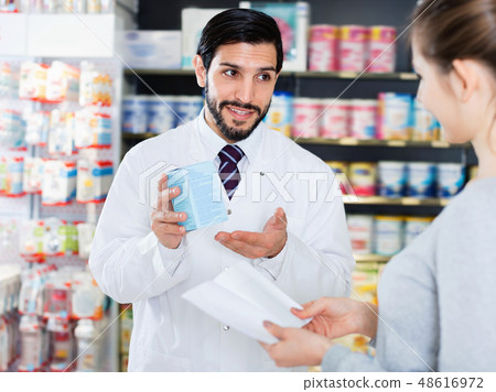 Male specialist is helping female client choose medicine in pharmacy. Male specialist is helping female client choose medicine in pharmacy. 48616972