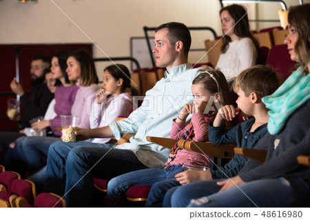 Happy group expecting movie to begin Happy group expecting movie to begin 48616980