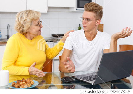 Woman scolding her upset adult son Woman scolding her upset adult son 48617069