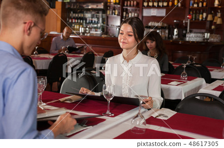 Girl with boyfriend choosing meal from menu 48617305