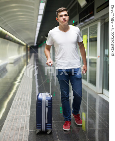 Man with luggage bag in subway station Man with luggage bag in subway station 48617442