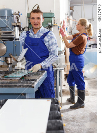 Male glazier working with glass on drilling machine 48617479