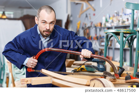 Carpenter using tools for creating furniture 48617500