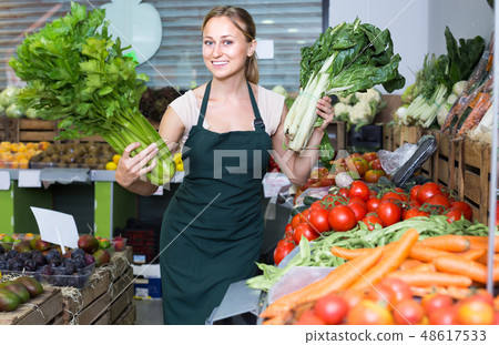woman selling fresh greens on market . 48617533