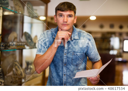 Man with brochure looking at exposition Man with brochure looking at exposition 48617534