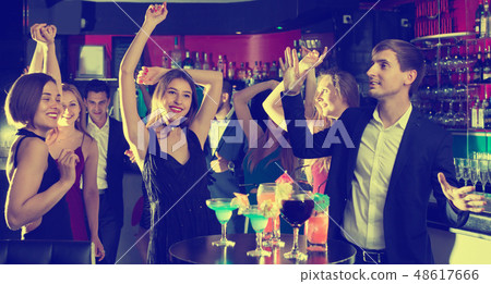 Colleagues dancing on corporate party with cocktails in hands 48617666