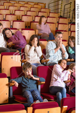 Group of people watching scary movie Group of people watching scary movie 48617667