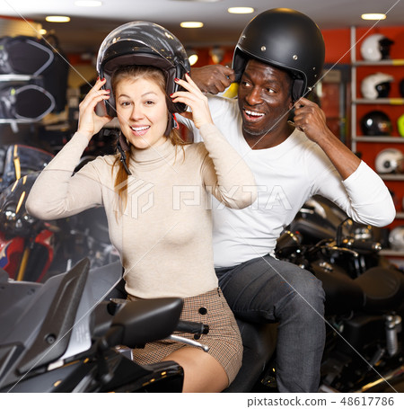 active man and woman posing on new motorcycle in shop active man and woman posing on new motorcycle in shop 48617786