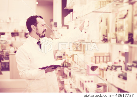 Pharmacist writing down assortment of drugs Pharmacist writing down assortment of drugs 48617787