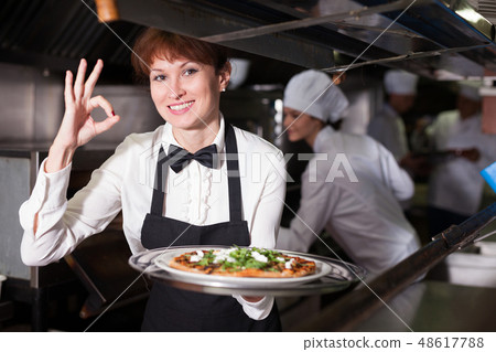Waitress with ordered dish in kitchen 48617788