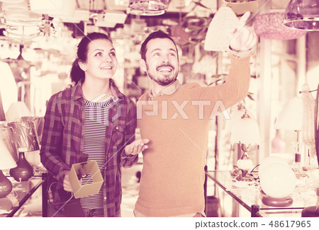 Couple enthusiastically considering the range of lamps 48617965