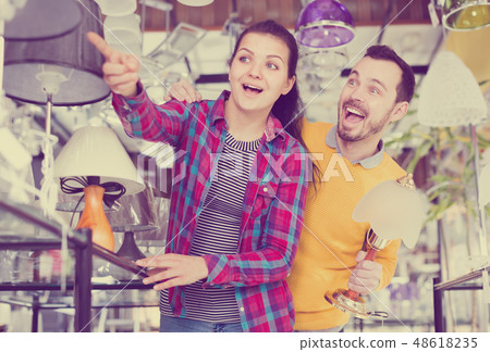 Smiling man and girl choose modern lamp 48618235