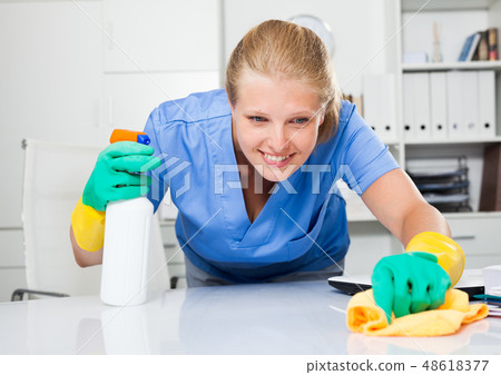 Professional cleaner cleaning desk 48618377