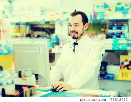 Pharmacist writing down assortment of drugs Pharmacist writing down assortment of drugs 48618412
