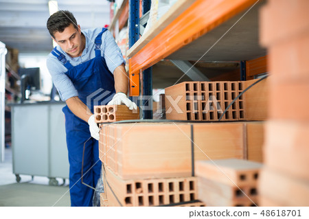 man is calculating bricks before selling man is calculating bricks before selling 48618701