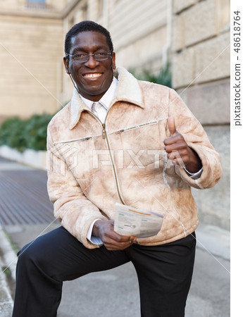 Man in warm jacket reading guidebook 48618764