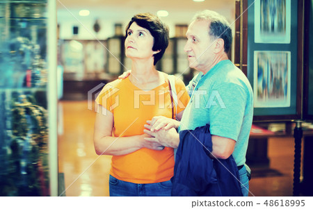 Romantic elderly couple interested in objects of applied arts in museum 48618995