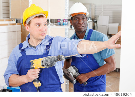 Builders using manual power tools 48619264