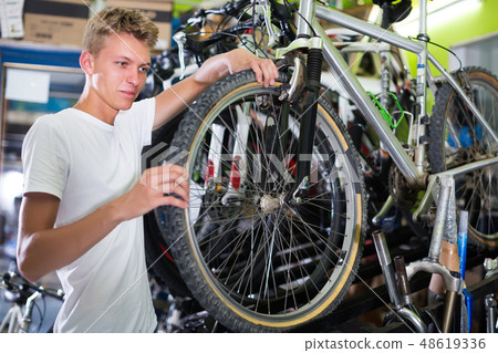 man checking tire on wheel man checking tire on wheel 48619336