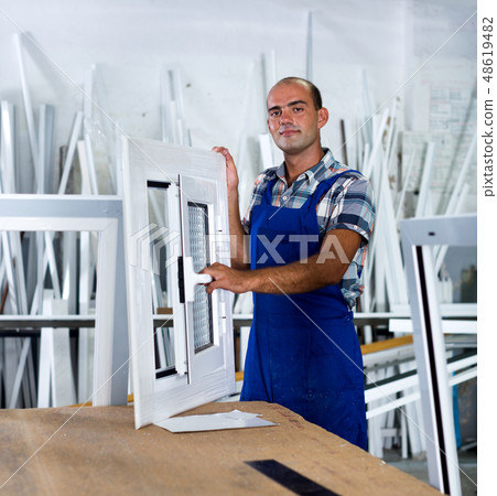Workman in blue overalls demonstrating pvc window Workman in blue overalls demonstrating pvc window 48619482