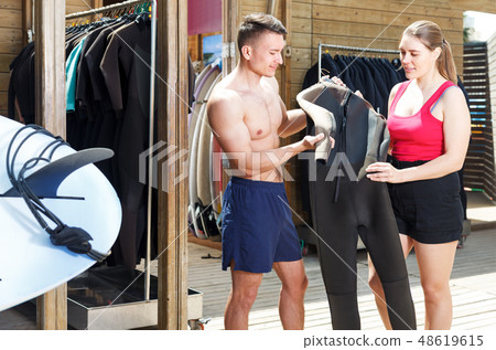 Couple choosing wetsuit in surf club 48619615