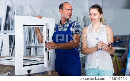 Supervisor woman and workman controlling quality of finished plastic glazed window Supervisor woman and workman controlling quality of finished plastic glazed window 48619624