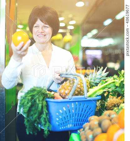 Middle aged woman choosing fruits and vegetables Middle aged woman choosing fruits and vegetables 48619677