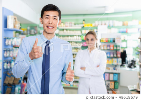 Portrait of smiling korean man client in pharmacy. Portrait of smiling korean man client in pharmacy. 48619679