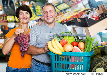 Couple demonstraiting basket with goods 48619685