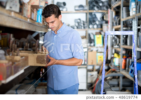 Male is choosing small details in boxes Male is choosing small details in boxes 48619774
