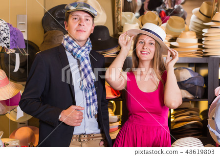 Woman and man trying on fashion hats 48619803
